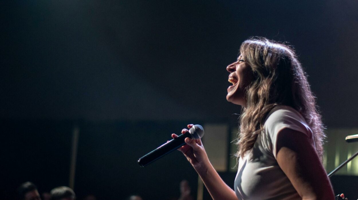 Cantautora actuando en escenario con iluminación cálida