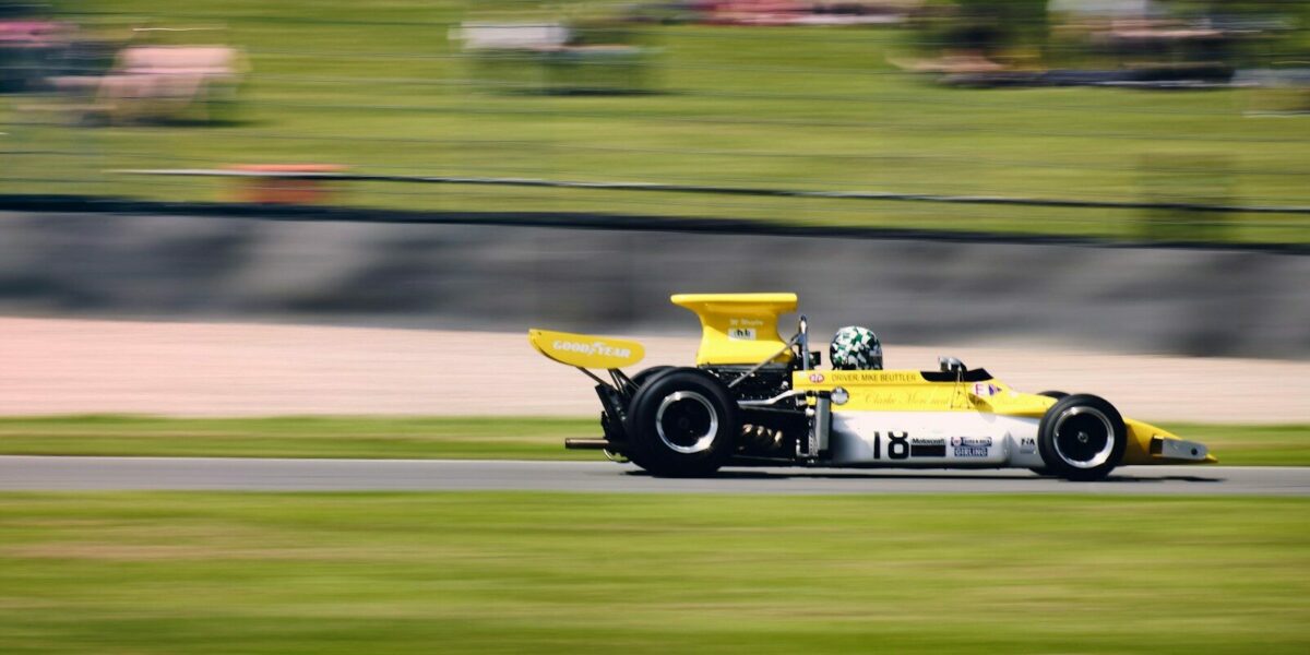 a yellow race car driving down a race track