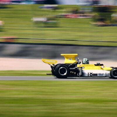 a yellow race car driving down a race track