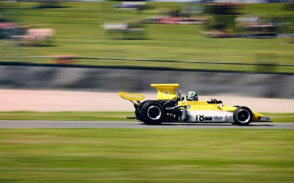 a yellow race car driving down a race track