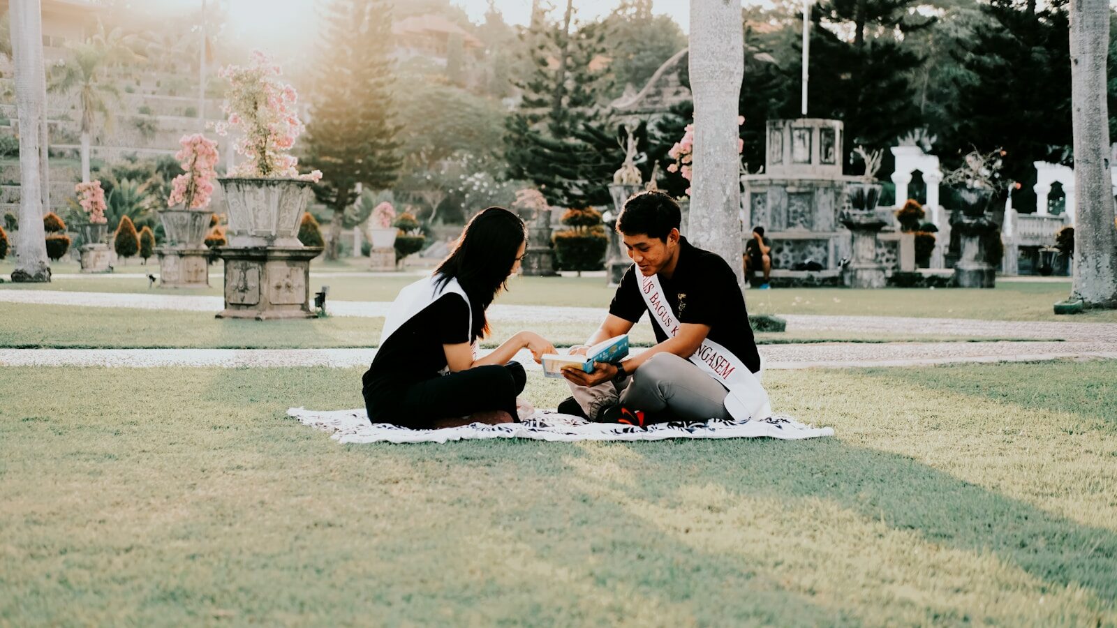 Pareja haciendo un picnic romántico sobre una manta en un parque