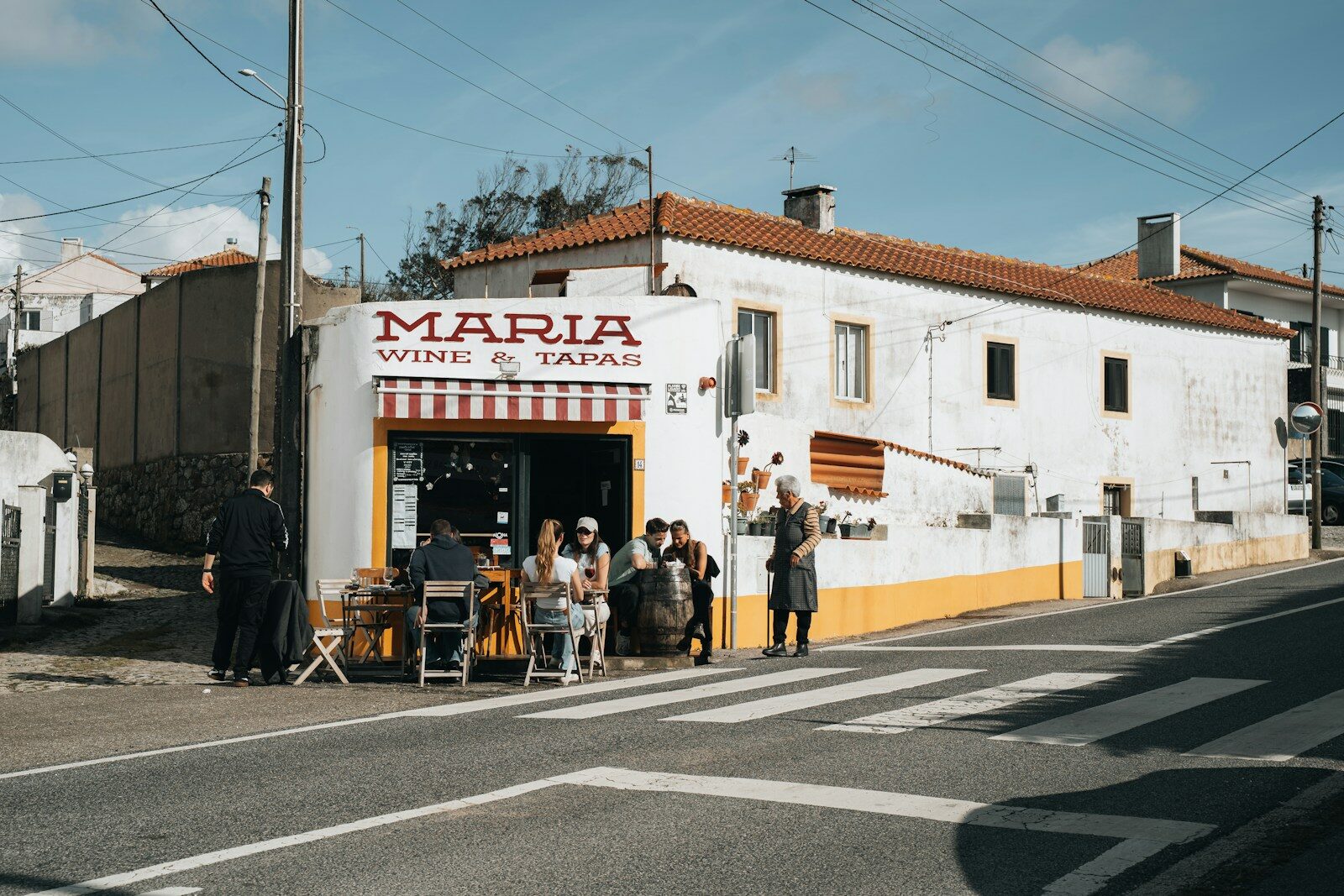 Gente sentada en la terraza de un bar de vinos y tapas