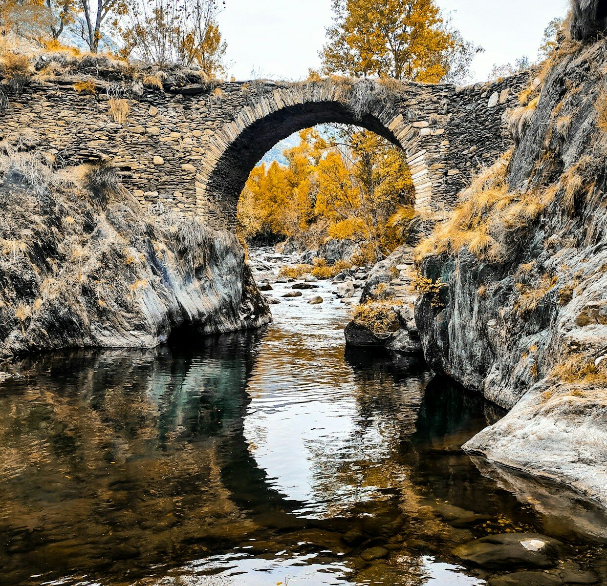 Puente de piedra sobre un río de montaña en la sierra