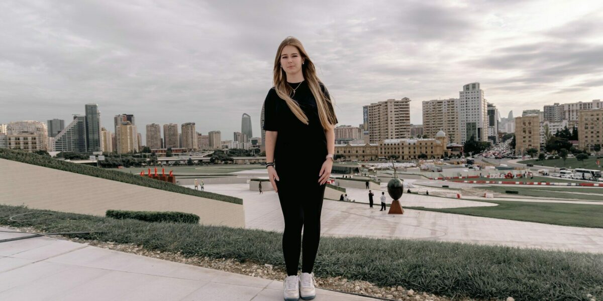 Young woman stands before a city skyline.
