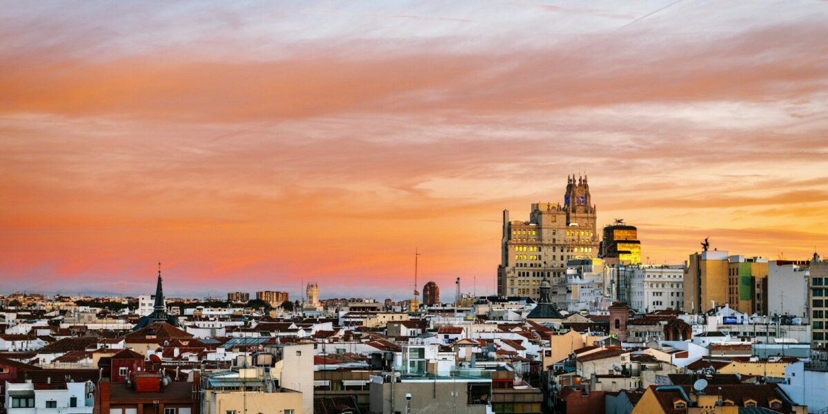city with high rise buildings under orange and gray skies during sunset