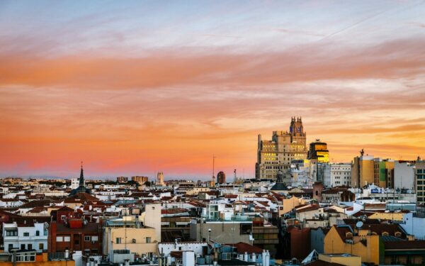 city with high rise buildings under orange and gray skies during sunset